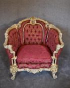 A cream and gilt Baroque style armchair in rouge buttoned damask upholstery. H.97 x 80cm