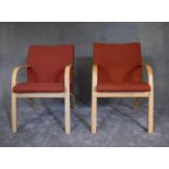 A pair of contemporary ash framed armchairs upholstered in orange fabric. H.55 x 52cm