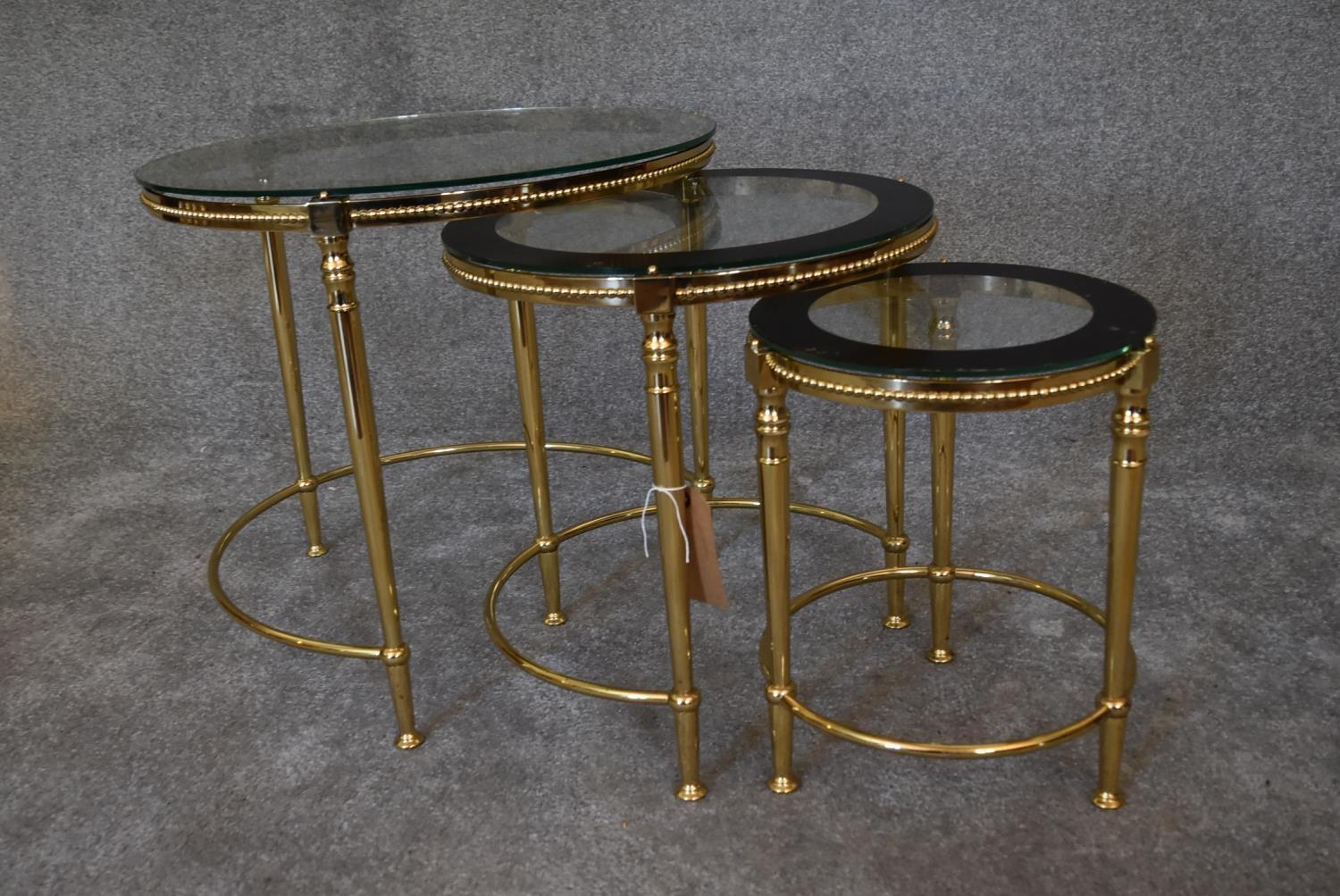 A nest of three brass circular graduating tables with clear glass tops and mirrored edges. Largest - Image 2 of 7