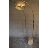 A large floor standing angle poise lamp with marble base and square section brass arm with large