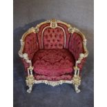 A cream and gilt Baroque style armchair in rouge buttoned damask upholstery. H.97 x 80cm