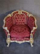 A cream and gilt Baroque style armchair in rouge buttoned damask upholstery. H.97 x 80cm