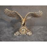 A large brass mantel clock in a naturalistically stylised case in the grasp of a flying eagle . 80cm