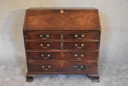 A Georgian mahogany bureau with fall front revealing fitted interior above four long drawers on