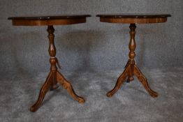 A pair of circular walnut occasional tables on tripod base. 55cm diameter.