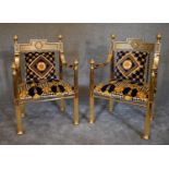 A pair of heavy brass framed Versace style armchairs with greek key pattern back rails and