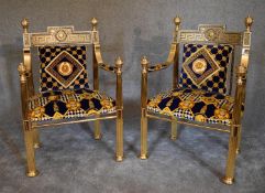 A pair of heavy brass framed Versace style armchairs with greek key pattern back rails and