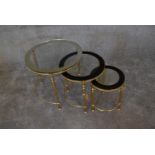 A nest of three brass circular graduating tables with clear glass tops and mirrored edges. Largest