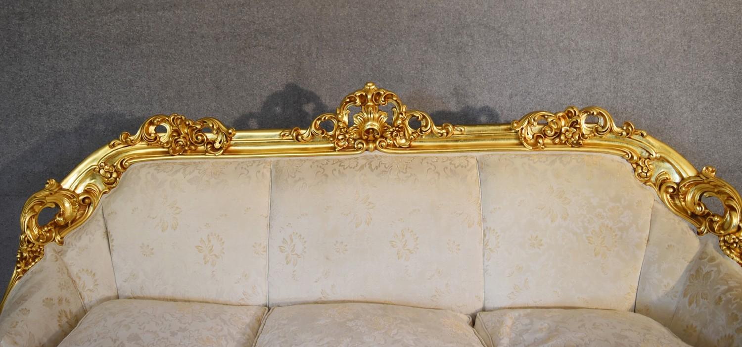 A heavily carved gilt framed Baroque style three cushion sofa with cream fabric and gold coloured - Image 4 of 5