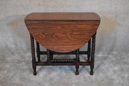 An 18th century country oak drop flap dining table with gateleg action on bobbin turned supports