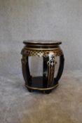 A black lacquered and gilt decorated Chinese stool. 50cm tall x 35cm diameter.