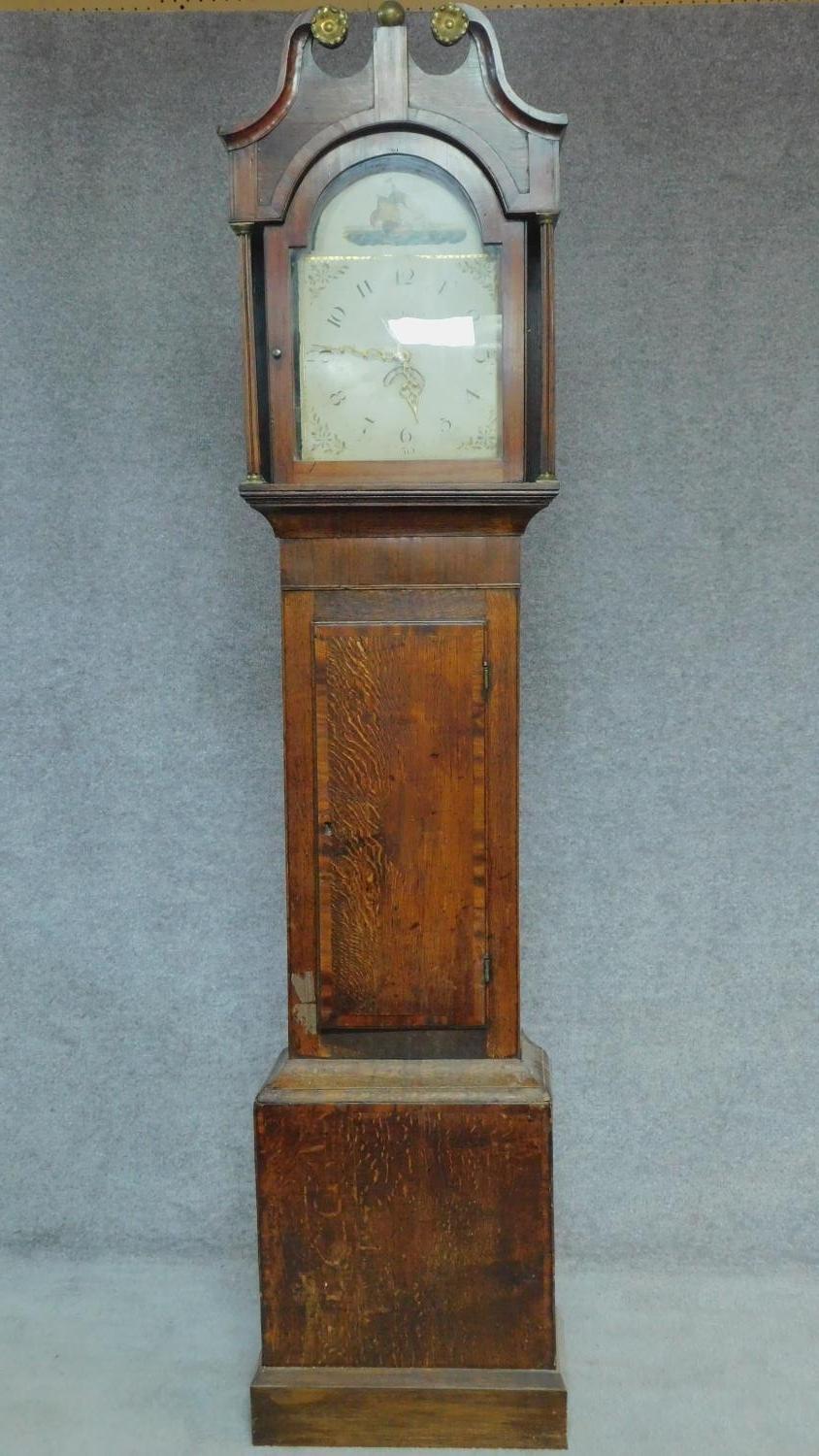 A 19th century oak cased longcase clock with painted arched dial. H.215cm