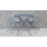 A metal circular garden table with a pair of matching gothic style chairs. H.76 W.74 D.74cm