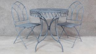 A metal circular garden table with a pair of matching gothic style chairs. H.76 W.74 D.74cm