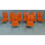 A set of eight orange painted plywood stacking chairs by allermuir. H.87cm