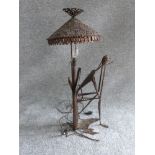 A vintage ironwork seated figure lamp in the style of Giacometti. Pierced conical shade. H 67.5cm