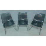Three smoked grey moulded tub chairs on chrome base. H.83cm