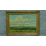 A gilt framed oil on canvas, rolling country landscape, artists label verso. 55x75cm