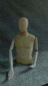 A moulded male mannequin, head and torso with articulated arms. H.80cm