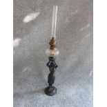 An Egyptian revival figure bronze oil lamp with original glass funnel and brass detailing. H71cm.