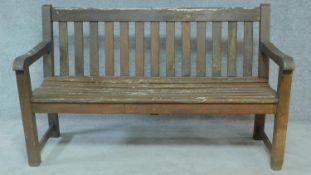 A weathered teak garden bench. H.90 W.148 D.60cm