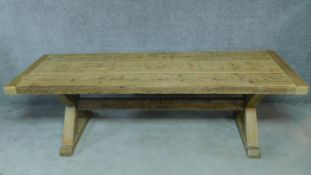 A large pitch pine refectory style dining table with planked top and cleated ends on X-frame