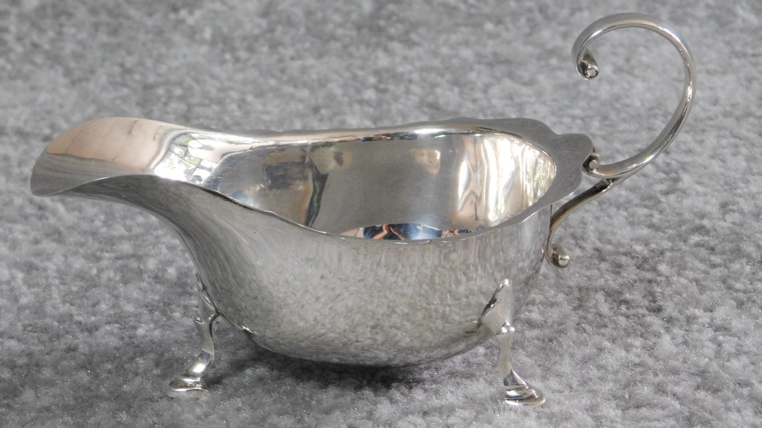 A hallmarked silver milk jug by Asprey & Co Ltd, London 1936. With elegant scrolling handle and