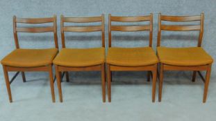 A set of four mid 20th century Danish teak dining chairs in mustard upholstery. H.77cm