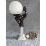 Art Deco style globe lamp with figure of dancer seated on a marble column. Figure made of resin,