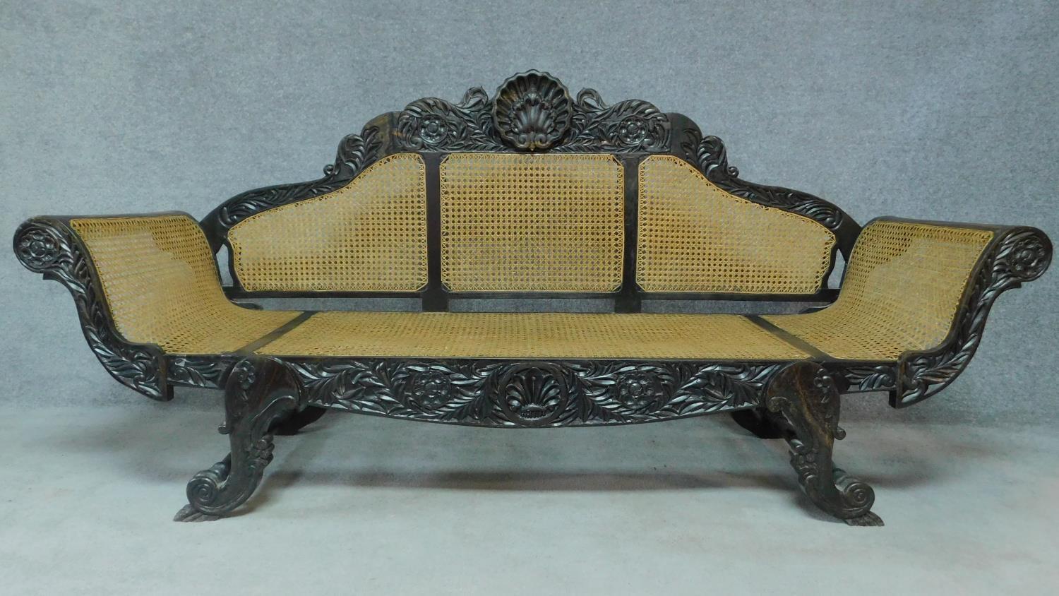 A Colonial style carved hardwood scroll end sofa with caned back and sides on scroll supports. H.101 - Image 2 of 9