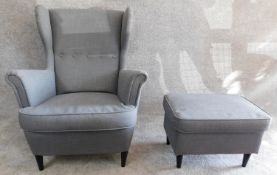 A contemporary vintage design wing back armchair and matching footstool. H.101cm