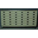 A large industrial style cabinet fitted with a bank of eighteen drawers and metal clad top on