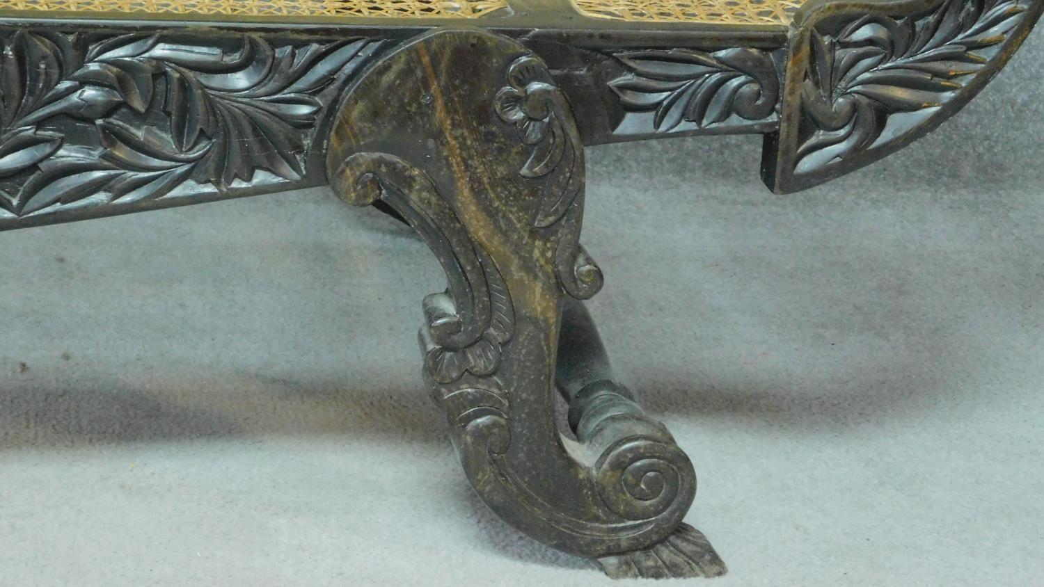 A Colonial style carved hardwood scroll end sofa with caned back and sides on scroll supports. H.101 - Image 4 of 9