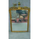 A late 19th century carved giltwood and gesso wall mirror with floral scroll cresting (parts