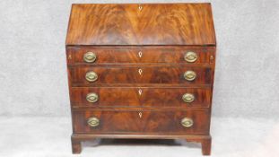 A Georgian flame mahogany bureau with fall front revealing fully fitted interior above four