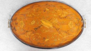 A late Victorian mahogany oval twin handled galleried tray with allover floral and musical intrument