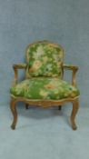 A carved beech framed French style fauteuil in green floral upholstery. H.96cm