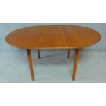 A mid 20th century Danish teak dining table fitted with extra fold out leaves. H.72 W.150 D.108cm