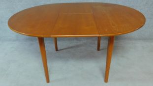 A mid 20th century Danish teak dining table fitted with extra fold out leaves. H.72 W.150 D.108cm