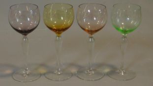 A set of four antique multicoloured hand blown wine glasses with clear stems. H.19cm