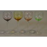 A set of four antique multicoloured hand blown wine glasses with clear stems. H.19cm