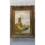 Ignatius Moogland (1889-1974), a gilt framed oil on canvas, windmill by a canal, signed. 81x61cm