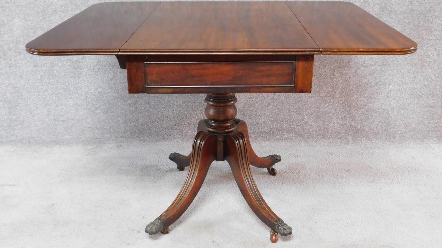 A Regency mahogany drop flap Pembroke table fitted end drawer on swept fluted quadruped supports.