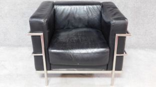 A black faux leather upholstered Le Corbusier style armchair with chrome tubular frame. H.74 W.94