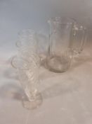 Three antique swirl hand blown wine glasses with polished pontil and a cut glass jug. Tallest 19cm.