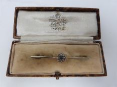 A diamond and sapphire 15 carat gold bar brooch, set to centre with a round old cut sapphire with an