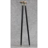 An ebonised walking stick with white metal handle and another similar. W.93cm