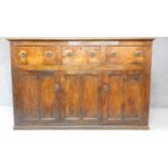 An antique country figured and burr elm dresser base fitted three frieze drawers above panel