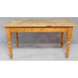 A pine planked top kitchen farmhouse table on turned tapering supports. H.78 W.152 D.81cm