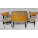 A mid 20th century teak drop flap dining table with ebonised base and a pair of matching dining